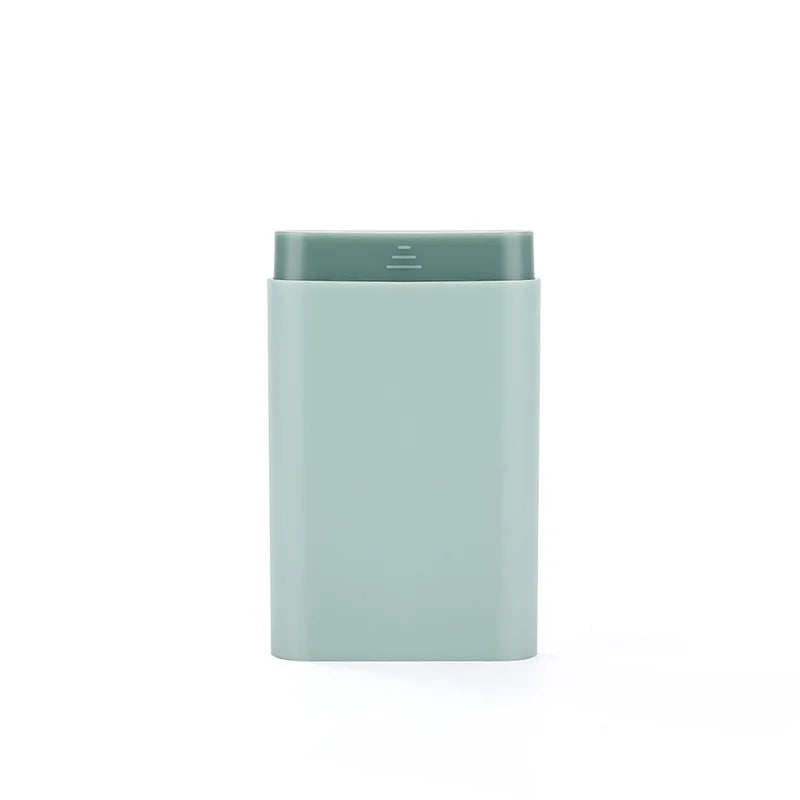 Rectangular light blue container with a green lid on a white background