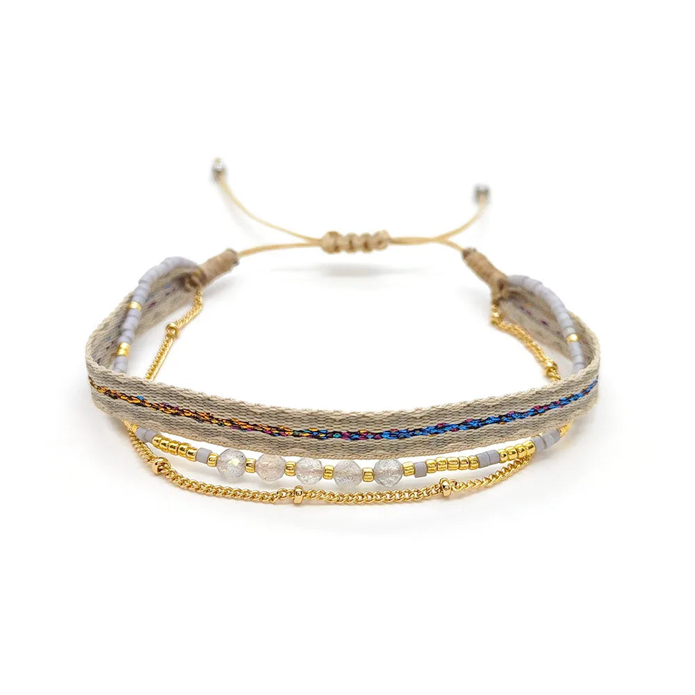 Multistrand beaded bracelet with gold accents on a white background