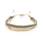 Multistrand beaded bracelet with gold accents on a white background