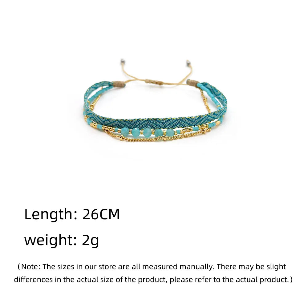 Teal braided bracelet with gold accents on a white background