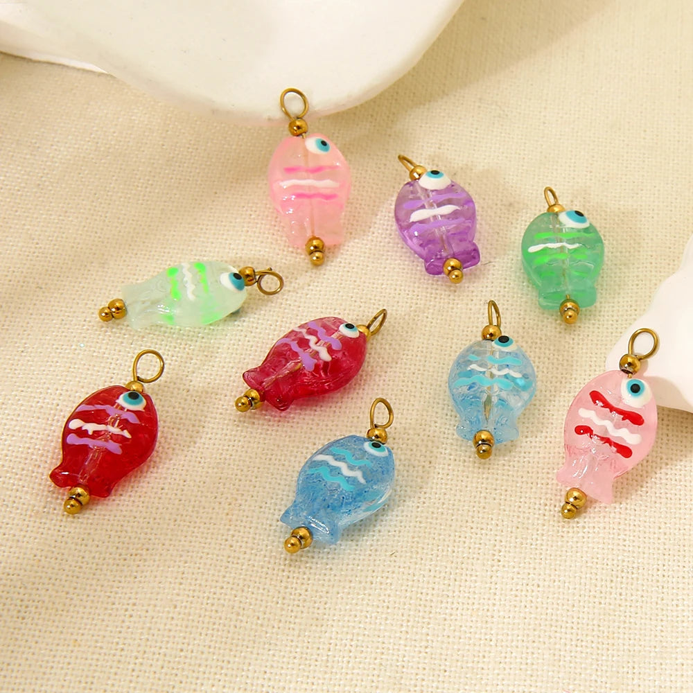 Colorful fish-shaped charms on a beige fabric background