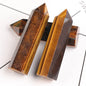 Two tiger eye crystal points on a white background
