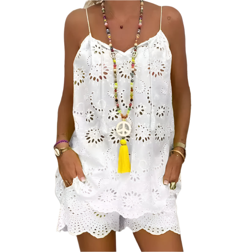 Woman wearing a white lace dress with a colorful necklace in a tropical setting