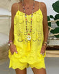 Person wearing a yellow lace dress with a decorative necklace against a blurred outdoor background