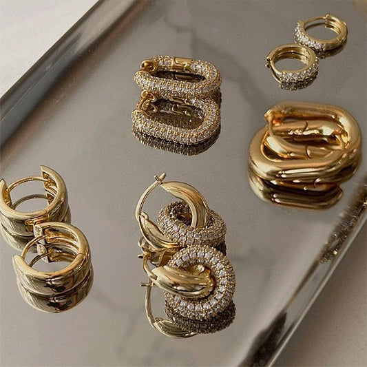 Gold hoop earrings on a reflective surface