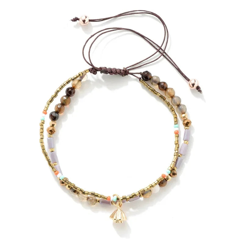 Multistrand beaded bracelet with a gold charm on a white background