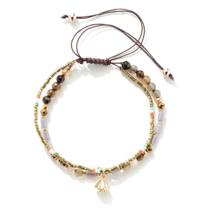 Multistrand beaded bracelet with a gold charm on a white background