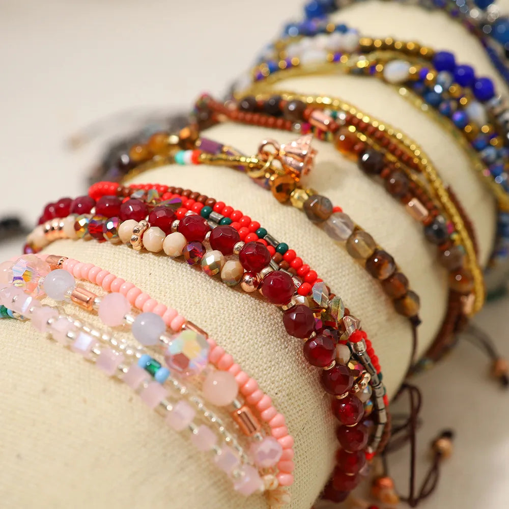 Stack of colorful beaded bracelets on a beige surface