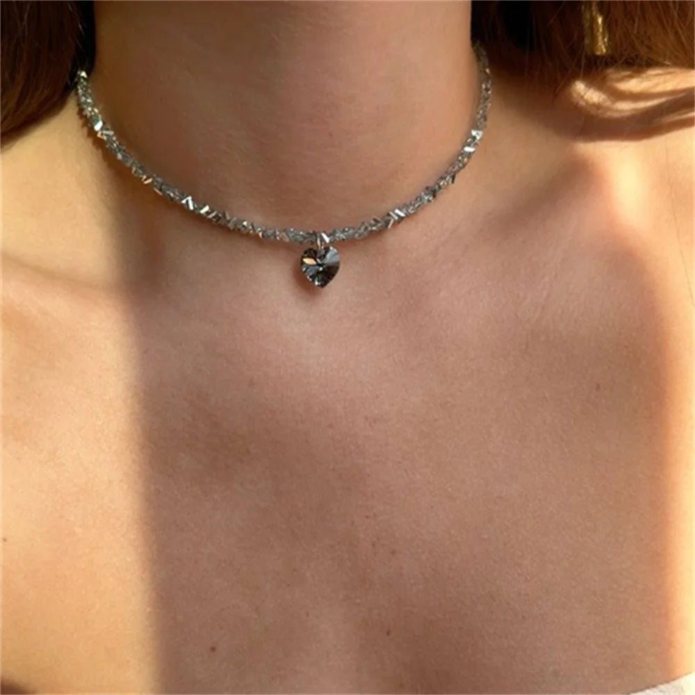Close-up of a silver necklace with a pendant on a person's neck