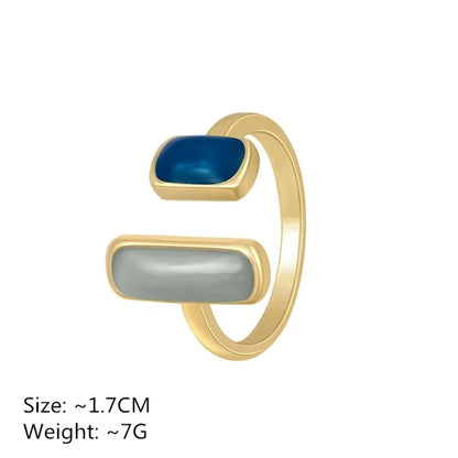 Gold ring with blue and gray stones on a white background
