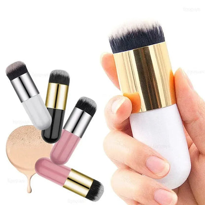 Set of makeup brushes with gold, silver, and black handles held by a hand.