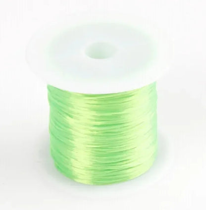 Spool of green thread on a white background