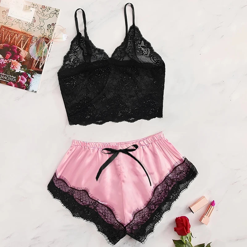 Black lace top and pink satin shorts with black lace trim on a light surface.