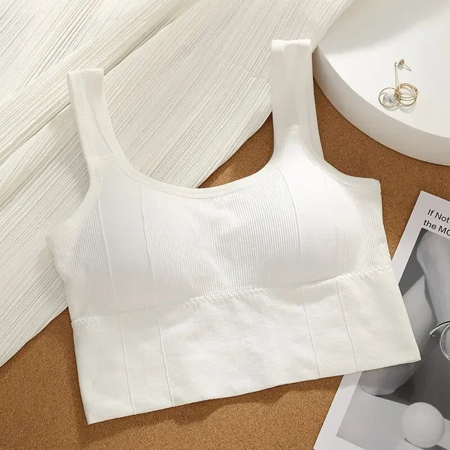 White bralette on a cork surface with a magazine and jewelry in the background