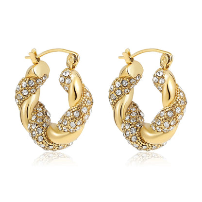 Gold hoop earrings with embedded crystals on a white background