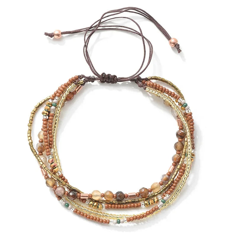 Multistrand beaded bracelet with brown cord on a white background