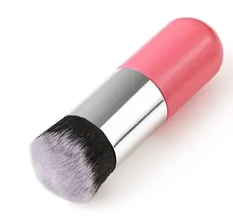 Makeup brush with pink handle and black bristles on a white background