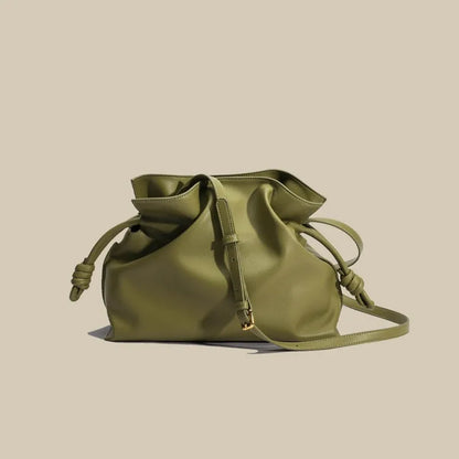 Green leather drawstring bag on a beige background