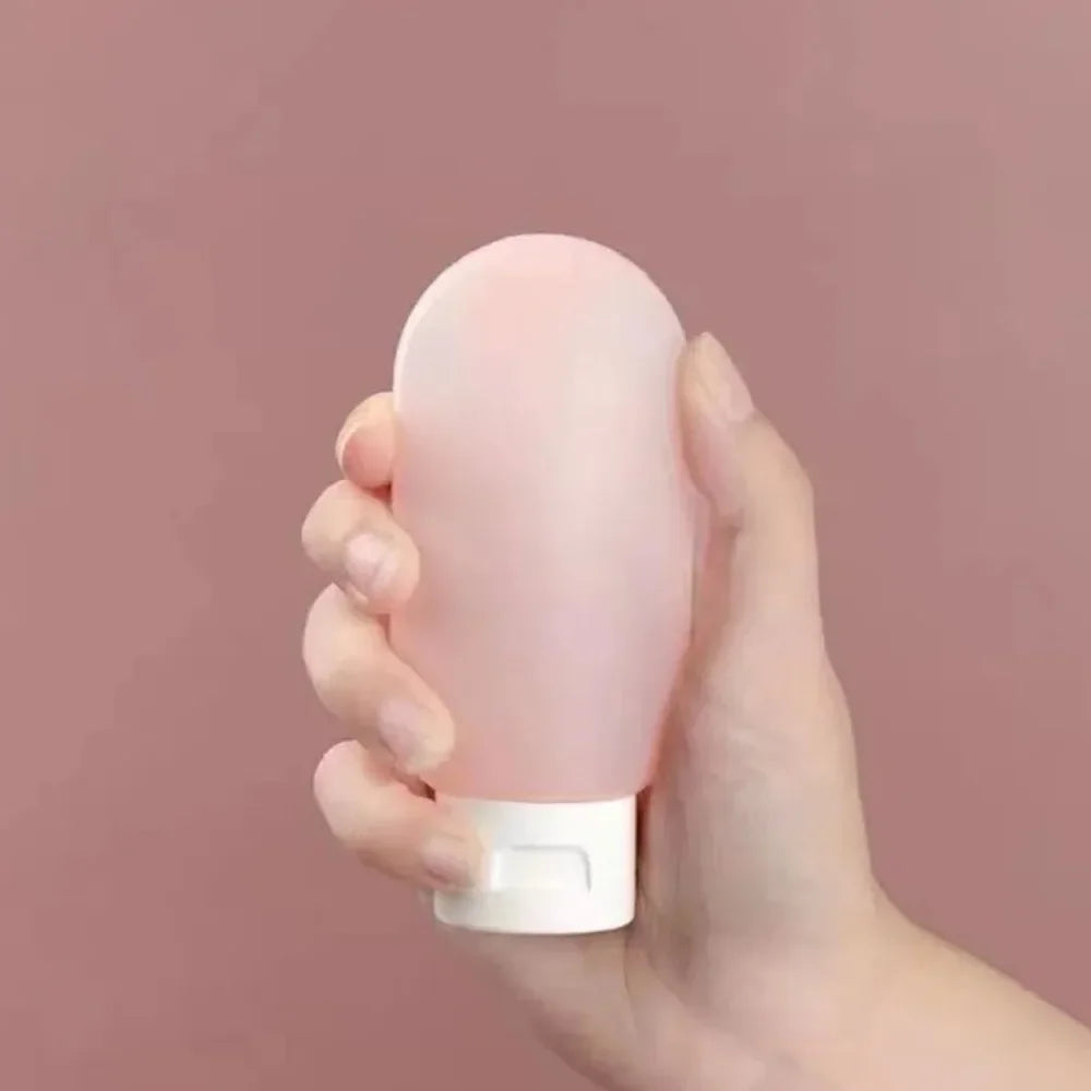 Hand holding a pink cylindrical object against a pink background