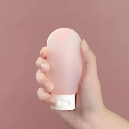 Hand holding a pink cylindrical object against a pink background