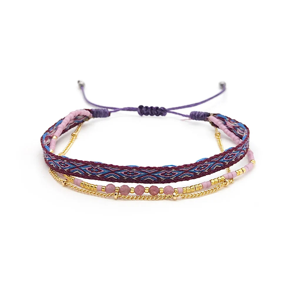 Multistrand bracelet with pink beads and gold accents on a white background