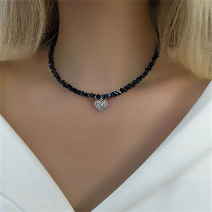 Necklace with heart-shaped pendant on a model wearing a white top