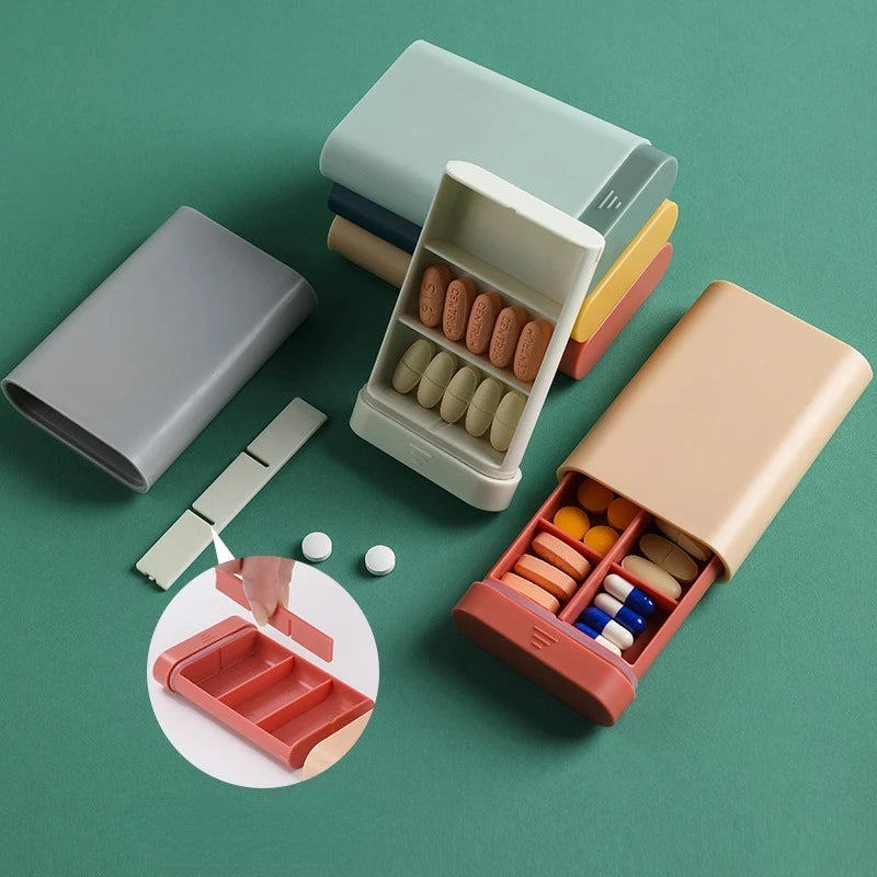 Set of pill organizers with different colors on a green background