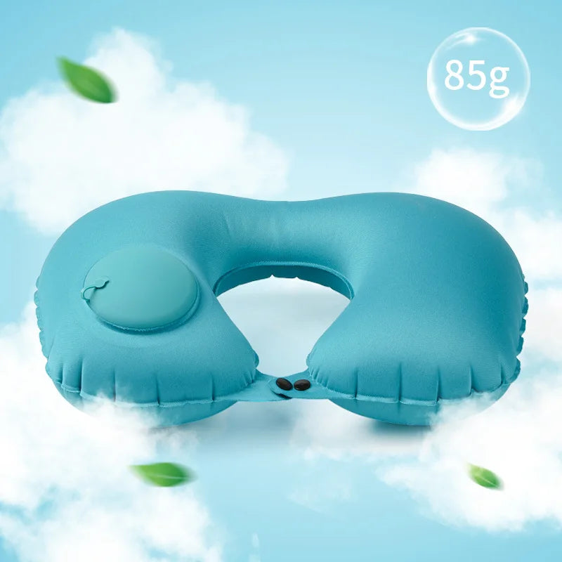 Blue inflatable travel pillow on a light blue background with green leaves.