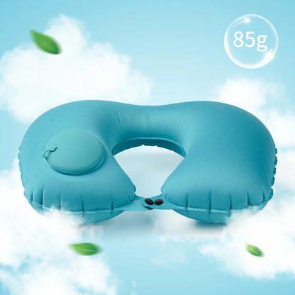 Blue inflatable travel pillow on a light blue background with green leaves.