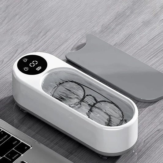 Eyeglasses in a white electronic device on a wooden surface