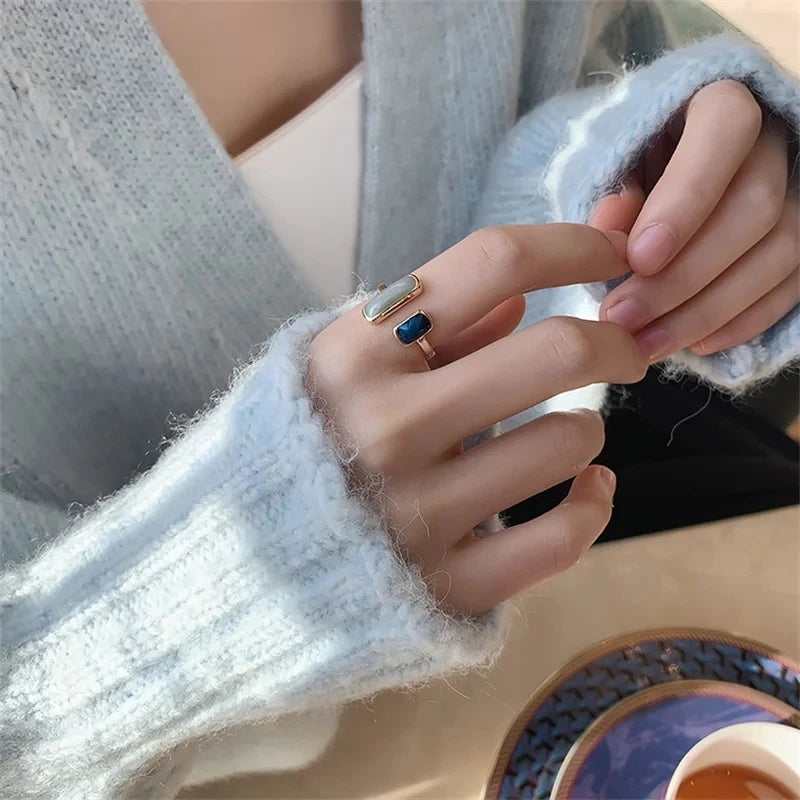 Close-up of a hand wearing two rings with a blurred background