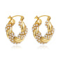 Gold hoop earrings with pearl accents on a white background