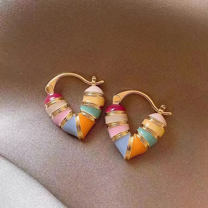 Colorful hoop earrings on a brown fabric background