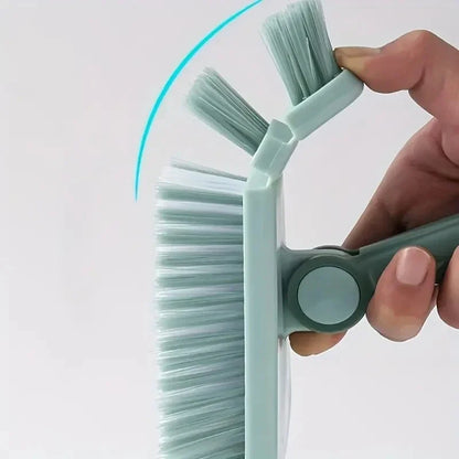 Hand holding a green cleaning brush against a white background