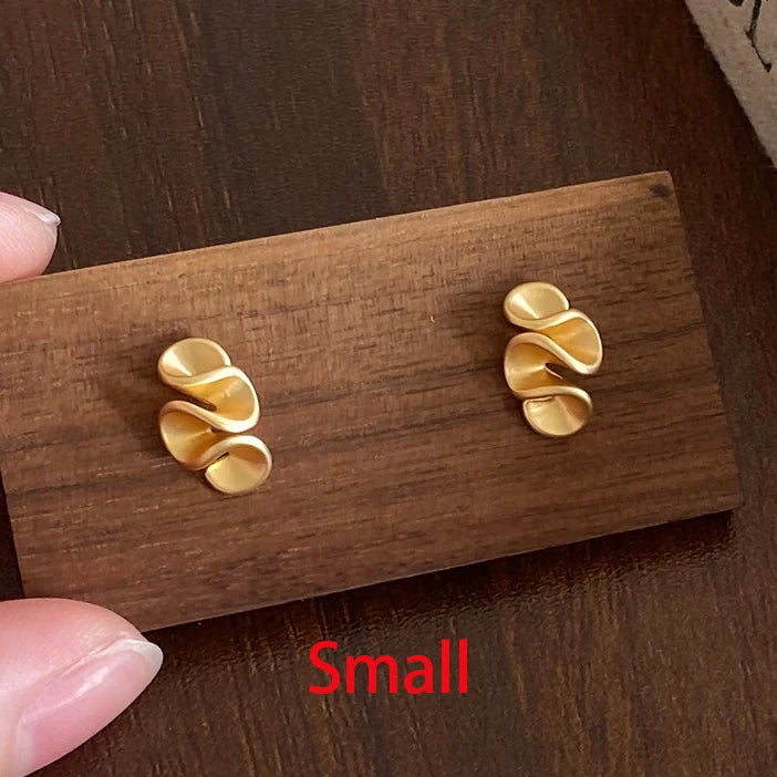 Gold earrings on a wooden display card with 'Small' label