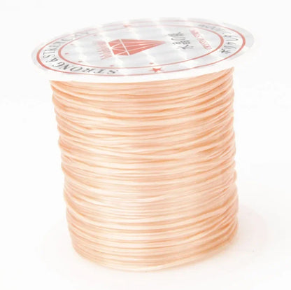 Spool of peach-colored thread with a brand label on a white background
