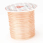 Spool of peach-colored thread with a brand label on a white background
