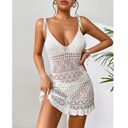 Woman wearing a white crochet dress against a light background