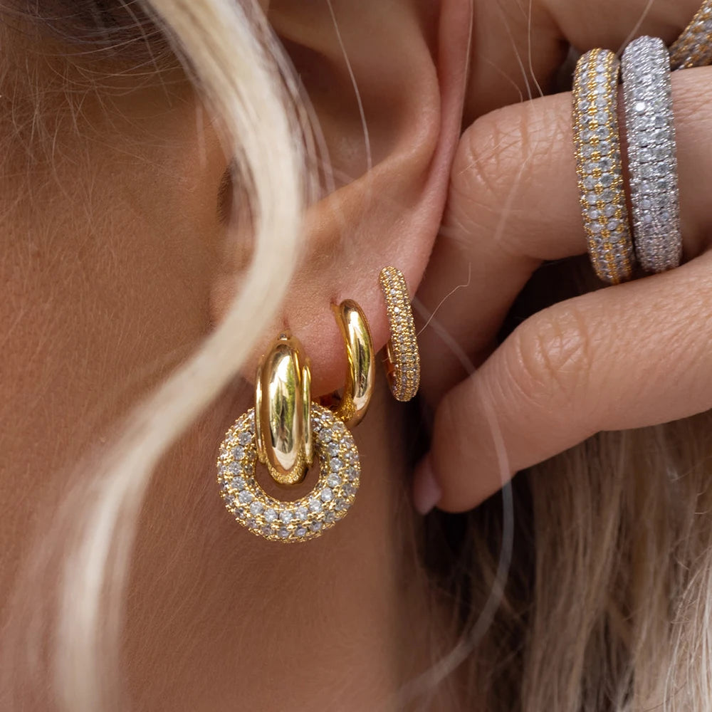 Gold hoop earrings worn by a person with blonde hair, close-up of ear.