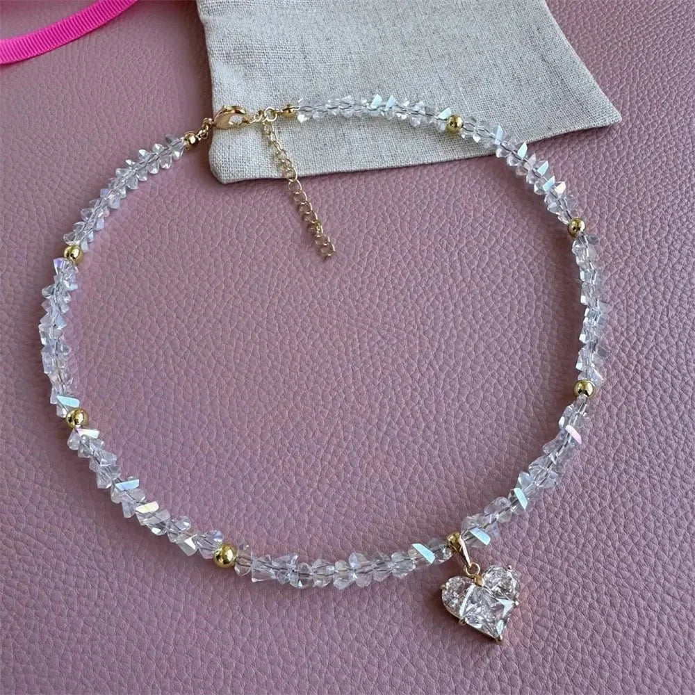 Necklace with a heart-shaped charm on a pink surface
