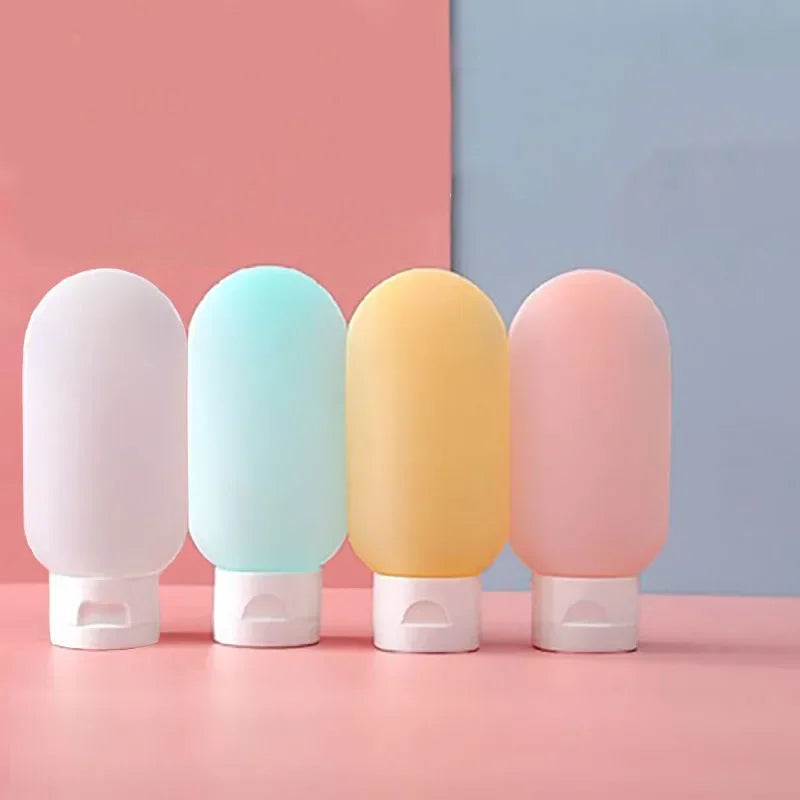 Four pastel-colored bottles with white caps on a pink and blue background