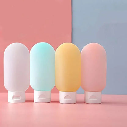 Four pastel-colored bottles with white caps on a pink and blue background