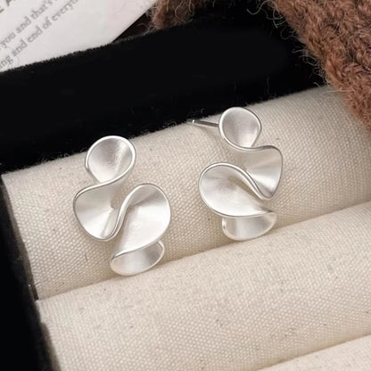 Silver abstract earrings on a jewelry display box