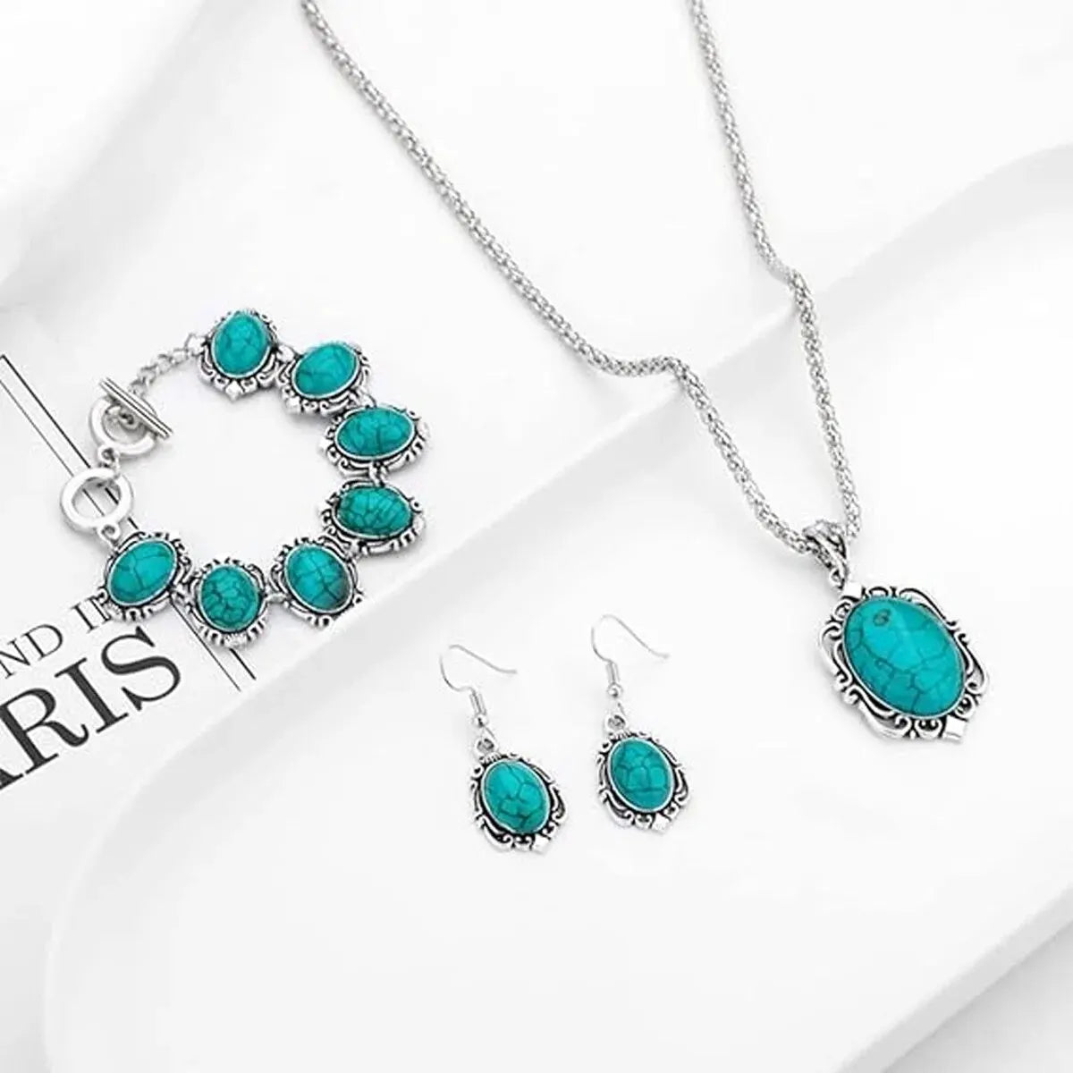 Turquoise jewelry set with necklace, bracelet, and earrings on a white background.
