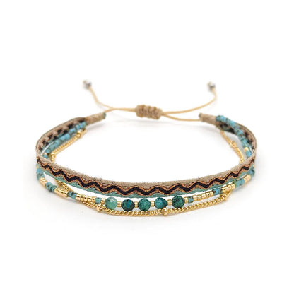 Multistrand bracelet with turquoise beads and gold accents on a white background